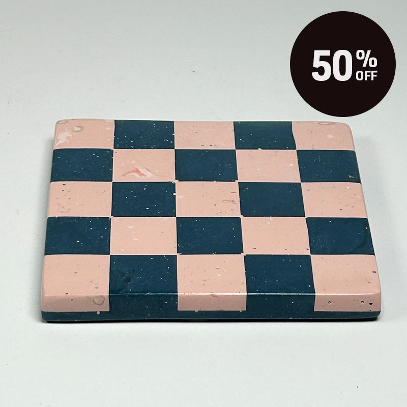 A square coaster with a navy blue and pink checkerboard pattern and a promotional badge with 50% off on top right corner
