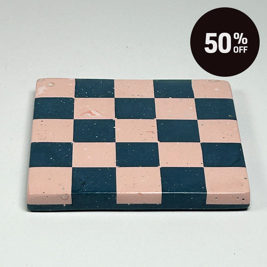 A square coaster with a navy blue and pink checkerboard pattern and a promotional badge with 50% off on top right corner