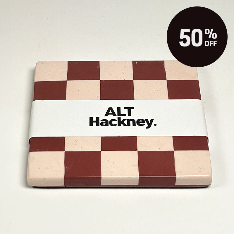 Dark red and light sand checkerboard patterned coaster on a white background, wrapped in a white paper band labeled 'ALT Hackney.', on a light off-white background with a black '50% OFF' promotional sticker in the top right corner.