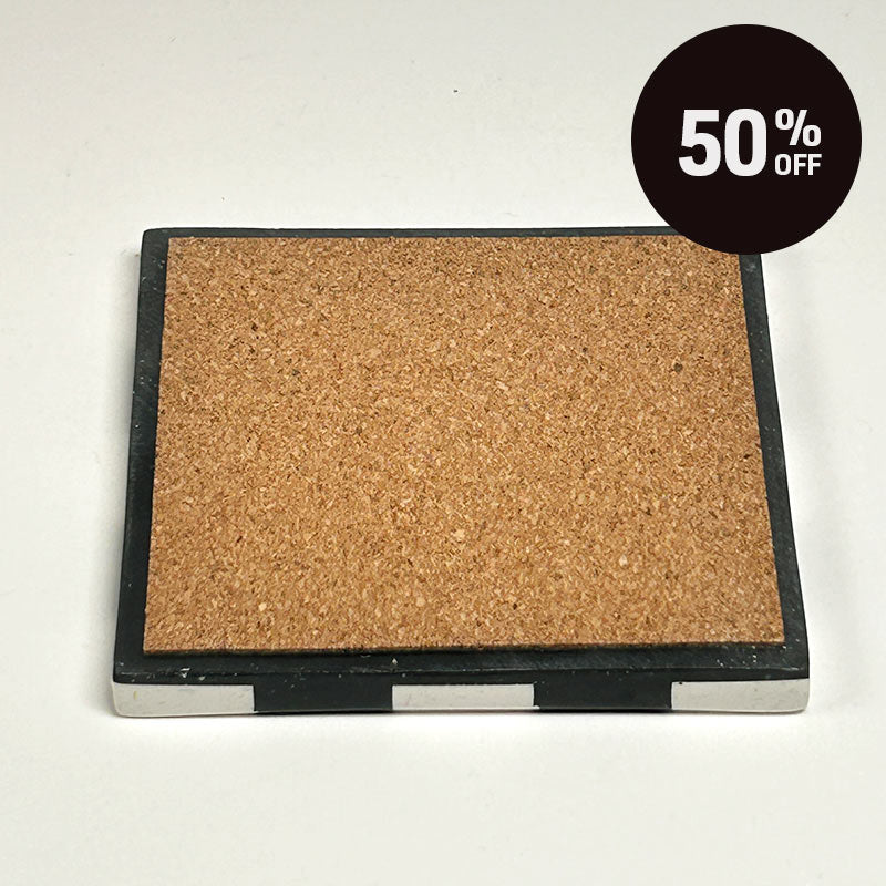 A square cork board with a square coaster with a black and white  checkerboard pattern and a promotional badge with 50% off on top right corner