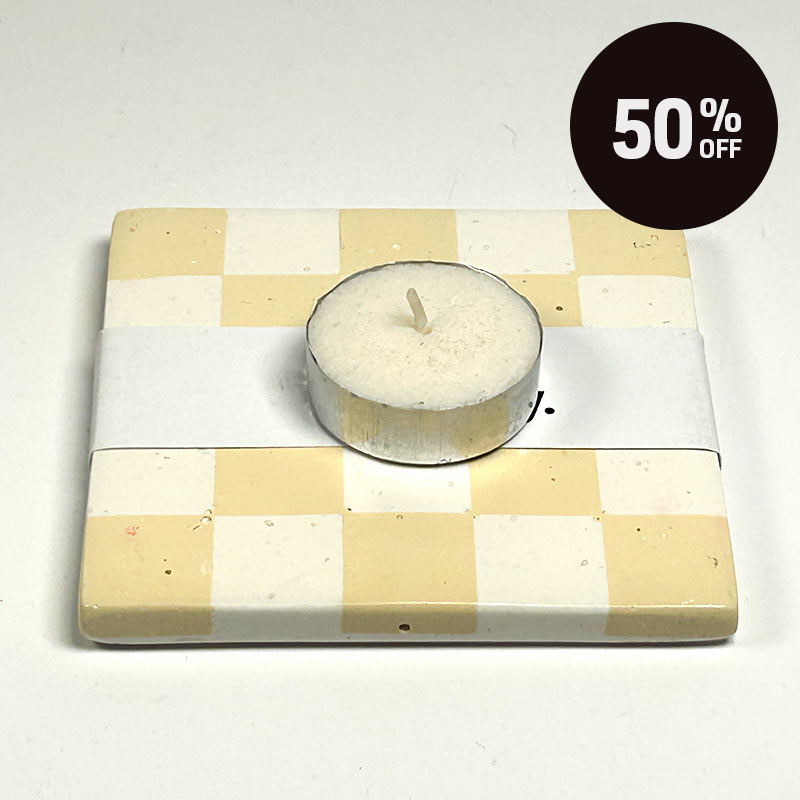 Warm beige and white checkerboard patterned coaster on a white background, wrapped in a white paper band labeled 'ALT Hackney.', on a light off-white background with a tea light candle and a black '50% OFF' promotional sticker in the top right corner.