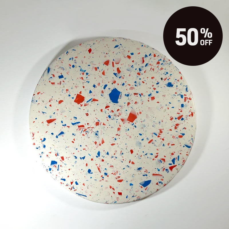 A round terrazzo tray with a white base and red and blue chips, shown on a white background with a black '50% OFF' promotional badge in the top right corner.