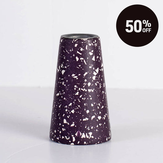 A terrazzo tapered candle holder dark purple with white speckles, shown on a clean white background with a black circular '50% OFF' promotional badge in the top right corner.