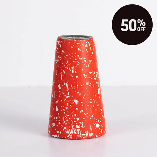 A terrazzo-style tapered candle holder vibrant red with white speckles, shown on a clean white background with a black circular '50% OFF' promotional badge in the top right corner.