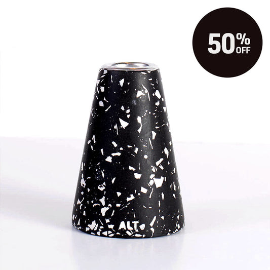 A black and white terrazzo-patterned taper candle holder with a silver-toned top, shown on a white background with a black '50% OFF' promotional badge in the top right corner.