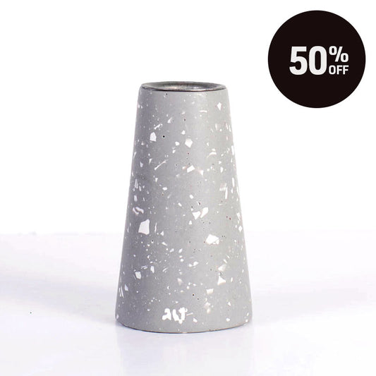A grey terrazzo tapered candle with white speckles, shown on a white background with a black circular '50% OFF' sale badge in the top right corner.