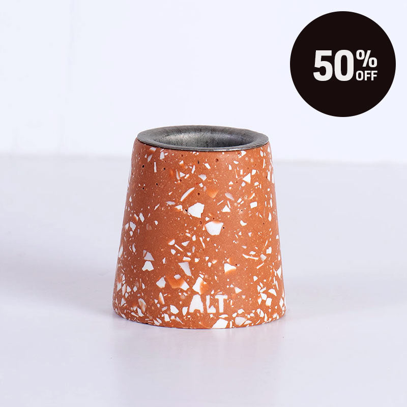 A terracotta-coloured white terrazzo taper candle holder against a plain white background with 50% off promotion badge