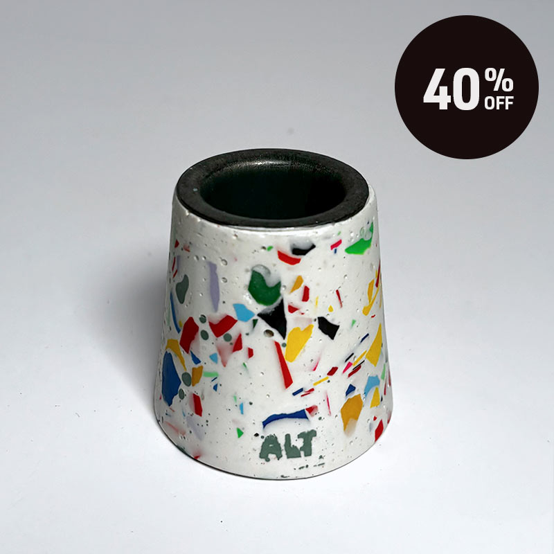 A small tapered taper candle holder with a terrazzo-style multicolour pattern on a white base, shown on a light grey background with a black '40% OFF' promotional badge in the top right corner.