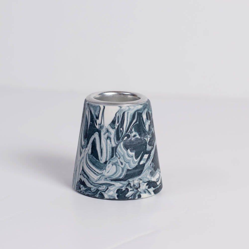 A marbled Navy and white small taper candle holderwith a silver metal inner rim, shown on a white background