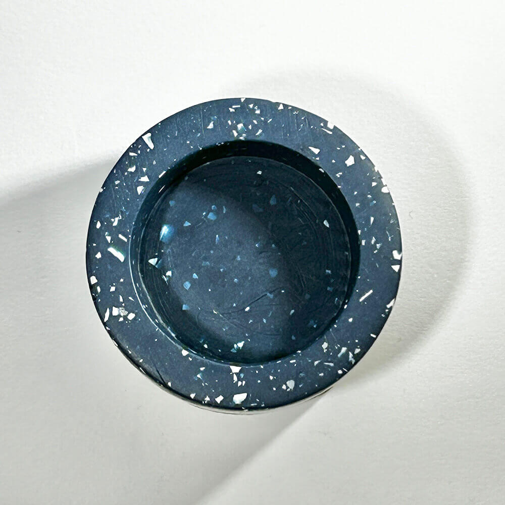 Navy blue terrazzo-patterned tealight candle holder on a white background