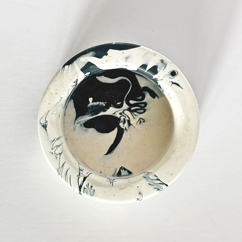 Marble-patterned navy and white tealight candle holder on a white background