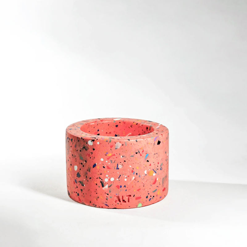 Pnk with rainbow confetti terrazzo-patterned tealight candle holder on a light gray background.