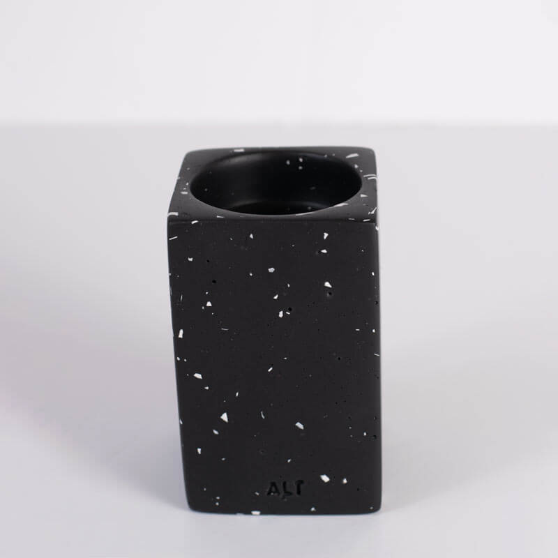 Black speckled ceramic vase on a light gray background
