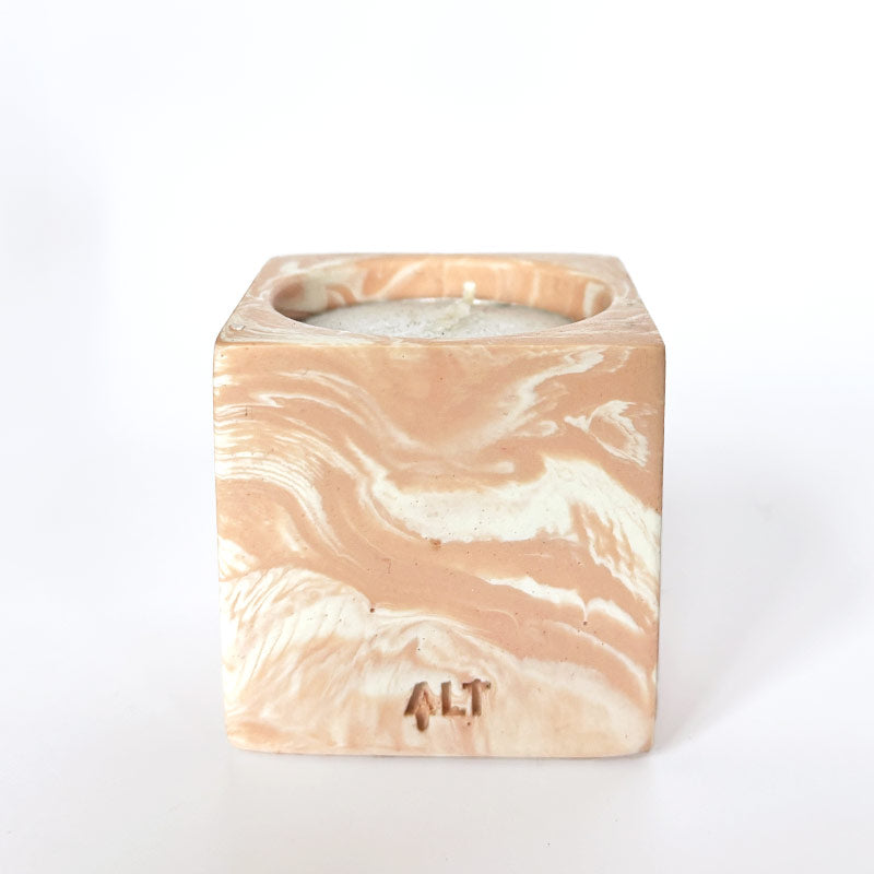 Marble-patterned salmon pink tea light candle holder with 'ALT' branding on a white background