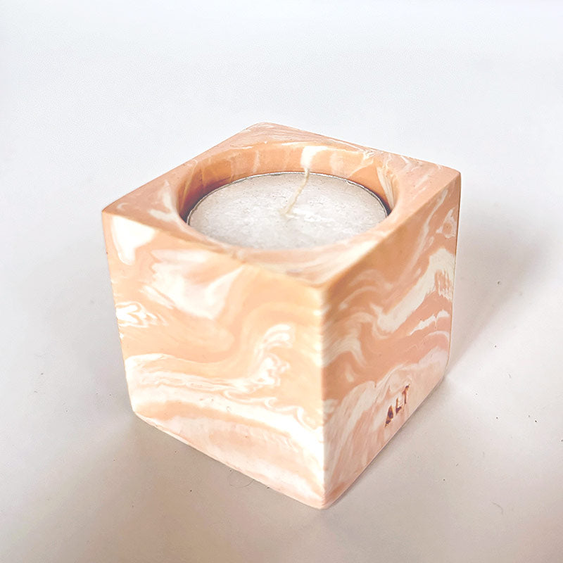 Marble-patterned salmon pink tea light candle holder with 'ALT' branding on a white background
