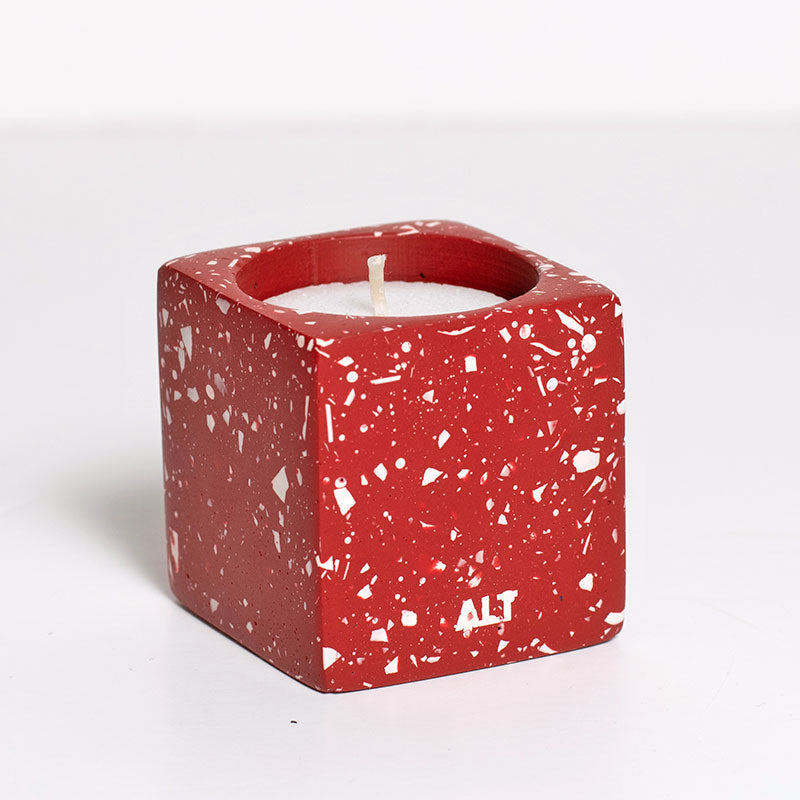 Red terrazzo candle holder with white candles on a white background