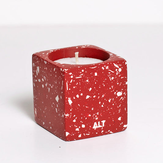 Red terrazzo candle holder with white candles on a white background