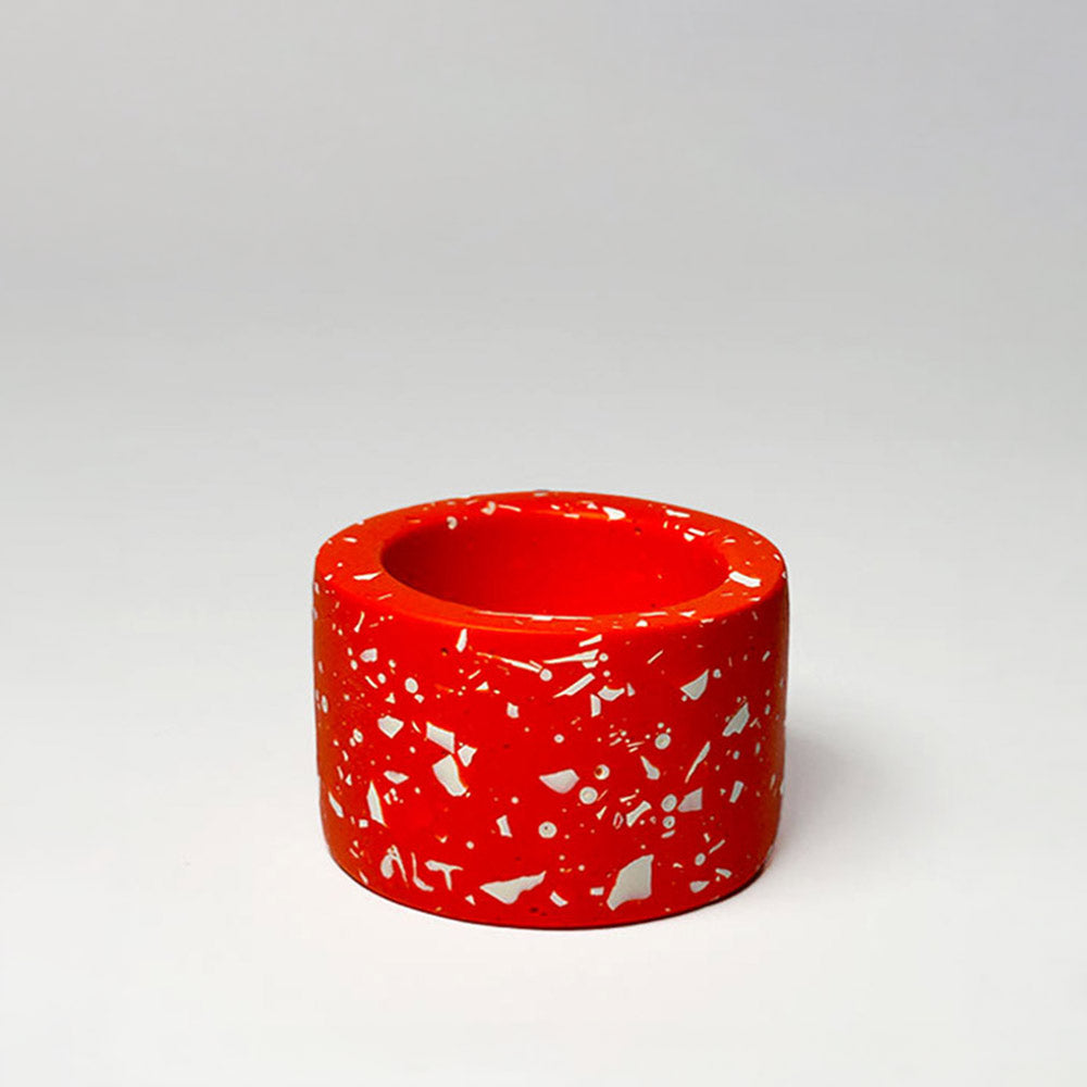 Red terrazzo-patterned tea light holder on a light grey background