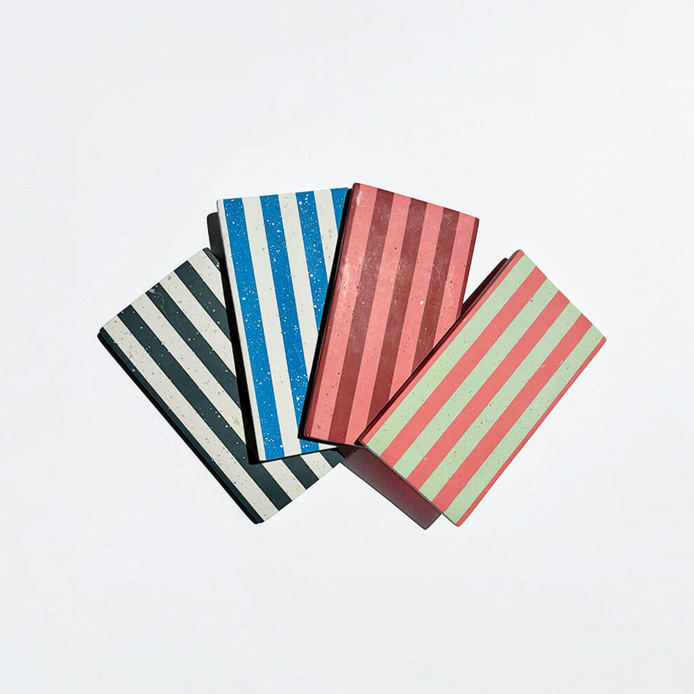 Multi coloured rectangular stripe trays on a white background